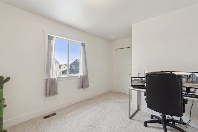 office area featuring visible vents, light carpet, and baseboards