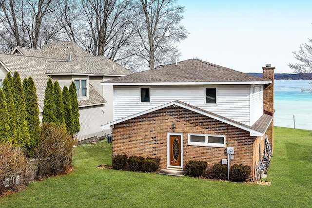 11375 SW Torch Lake Dr, Rapid City, MI 49676 - rear view of house with a lawn, a chimney, and brick siding