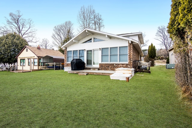 11375 SW Torch Lake Dr, Rapid City, MI 49676 - rear view of house featuring a deck, a lawn, and brick siding