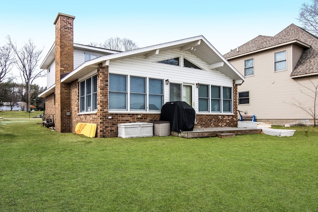 11375 SW Torch Lake Dr, Rapid City, MI 49676 - rear view of house with brick siding, a chimney, and a lawn