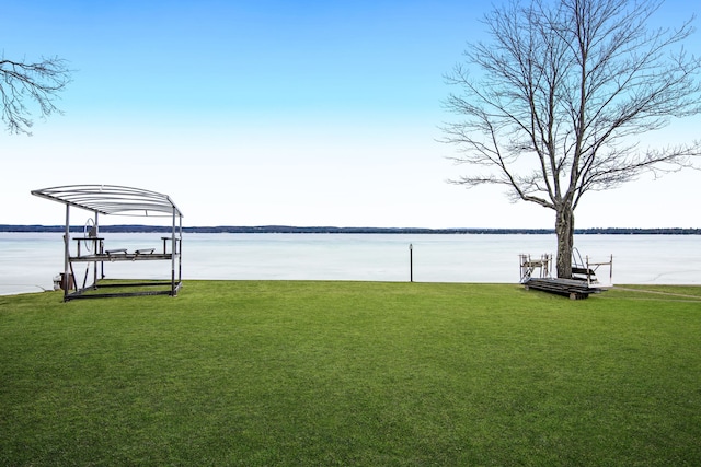 11375 SW Torch Lake Dr, Rapid City, MI 49676 - dock area with boat lift, a yard, and a water view