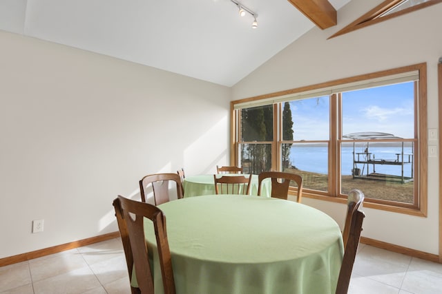 11375 SW Torch Lake Dr, Rapid City, MI 49676 - dining area with a water view, light tile patterned floors, baseboards, and rail lighting