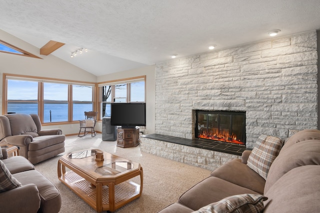 11375 SW Torch Lake Dr, Rapid City, MI 49676 - carpeted living room featuring a textured ceiling, a fireplace, vaulted ceiling, and baseboards