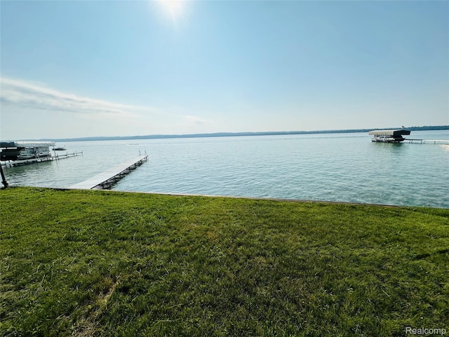 11375 SW Torch Lake Dr, Rapid City, MI 49676 - dock area featuring a lawn and a water view