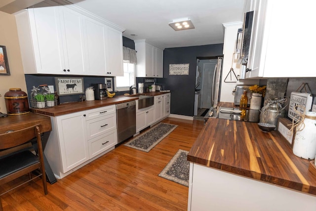 kitchen featuring a sink, butcher block countertops, white cabinets, light wood-style floors, and dishwasher