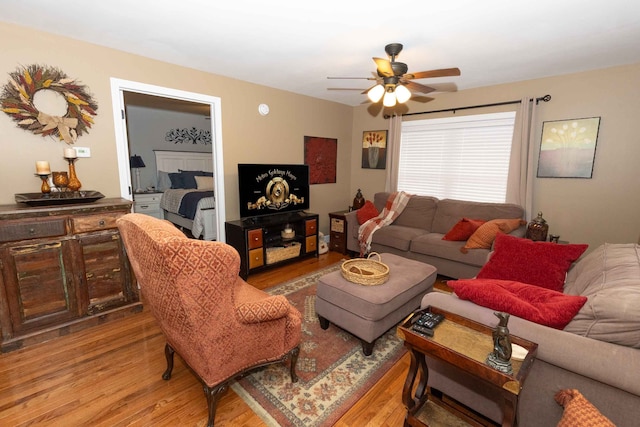 living area with light wood-type flooring and a ceiling fan