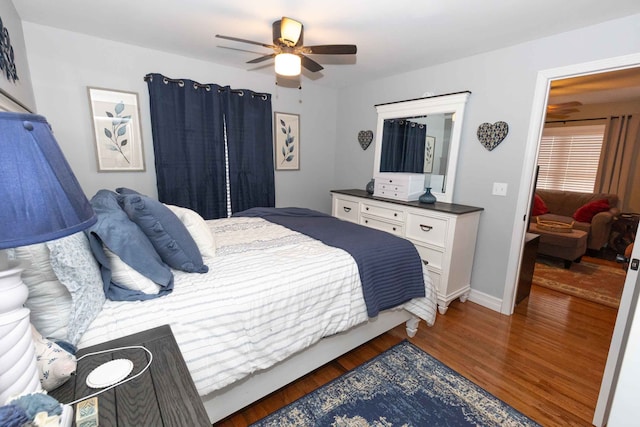 bedroom featuring ceiling fan, baseboards, and wood finished floors