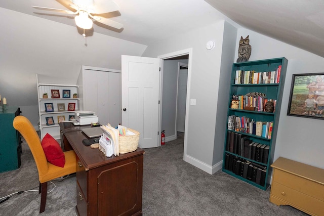 carpeted office space featuring baseboards, ceiling fan, and vaulted ceiling