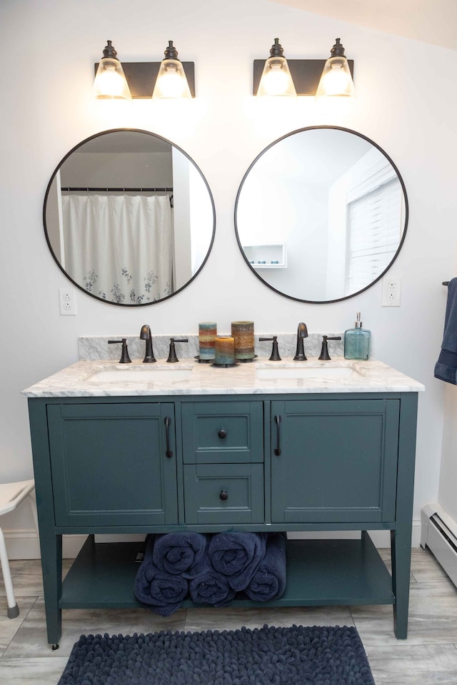 bathroom with double vanity, a baseboard radiator, and a sink