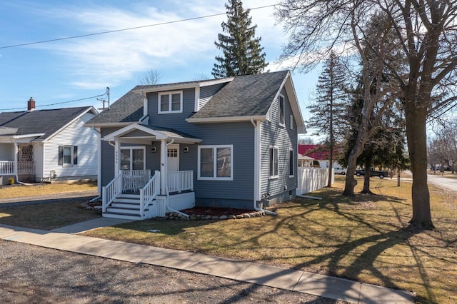 view of front of home with a front lawn and a shingled roof