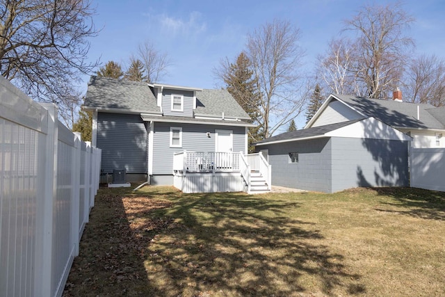 rear view of house featuring central air condition unit, fence, a lawn, and a wooden deck