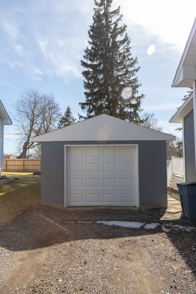 detached garage with fence and driveway