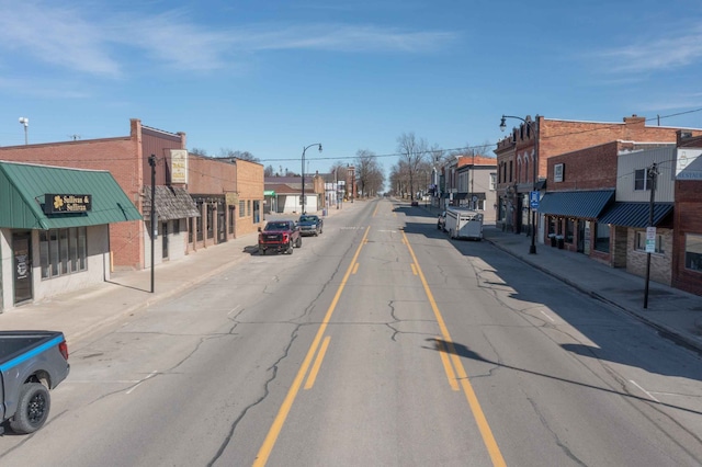 view of road featuring a residential view, curbs, street lights, and sidewalks