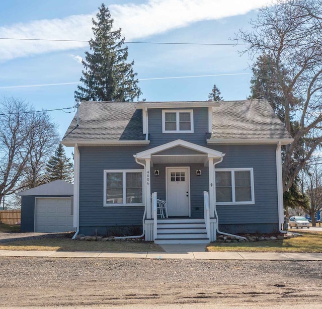 bungalow-style house with an outbuilding, a detached garage, and roof with shingles