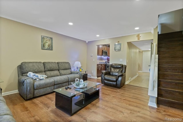 living room featuring light wood-type flooring, stairway, baseboards, and recessed lighting