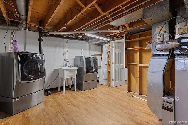 washroom with wood finished floors, laundry area, and separate washer and dryer