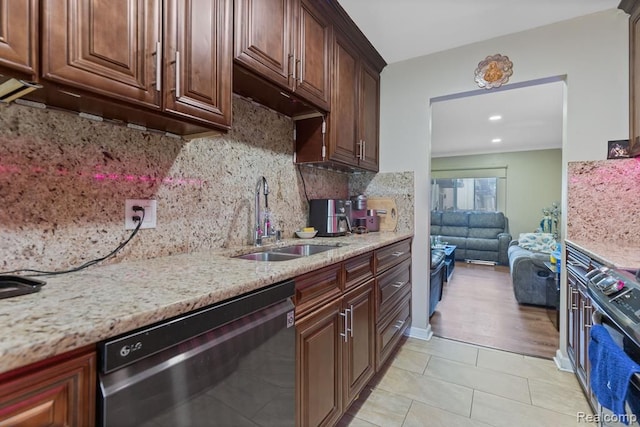 kitchen featuring light tile patterned floors, decorative backsplash, dishwasher, light stone counters, and a sink