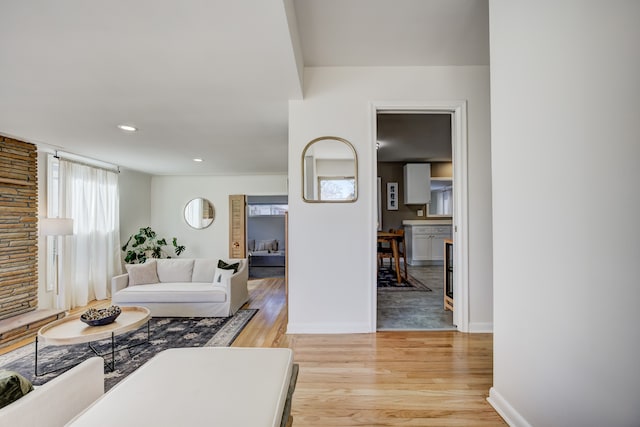 living room with light wood-type flooring, baseboards, and recessed lighting