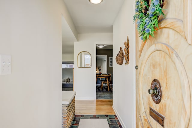 hallway with dark wood-style floors and baseboards