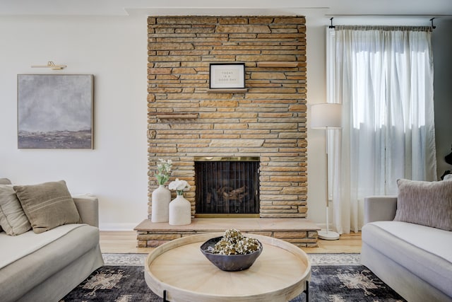 living room with a fireplace and wood finished floors