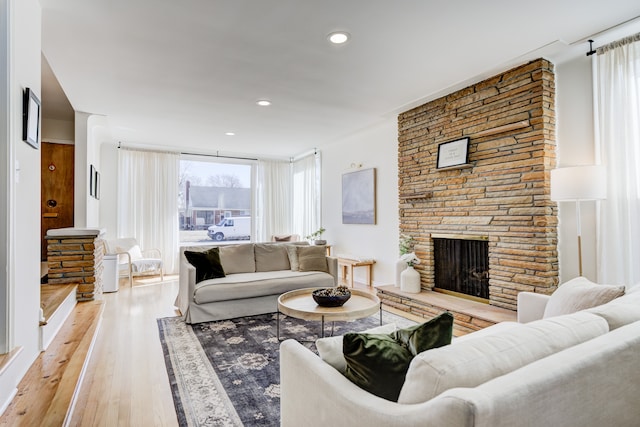 living area with recessed lighting, a fireplace, and wood finished floors