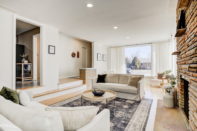 living room featuring light wood-style floors, a fireplace, and recessed lighting