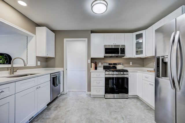 kitchen with stainless steel appliances, white cabinets, a sink, and glass insert cabinets