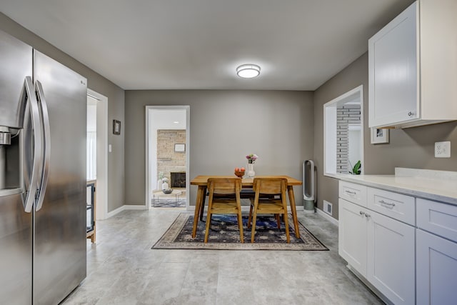 dining area featuring a fireplace, visible vents, and baseboards