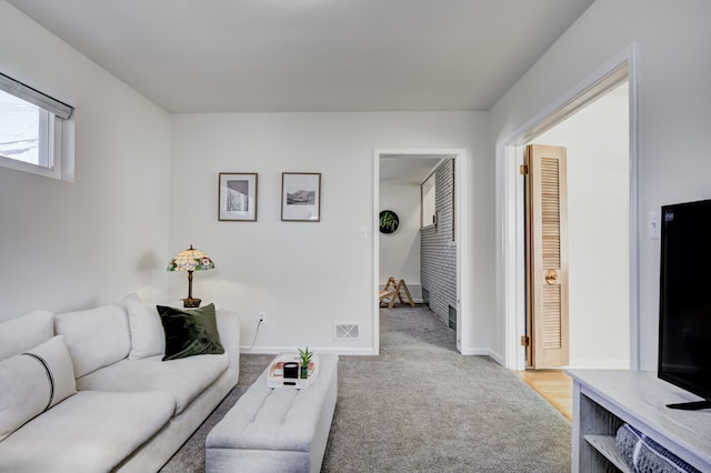 living room with visible vents, light carpet, and baseboards