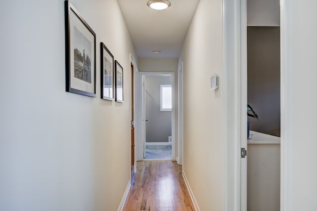 hallway featuring baseboards and wood finished floors