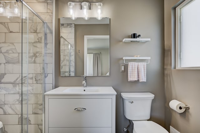 bathroom featuring a stall shower, vanity, and toilet