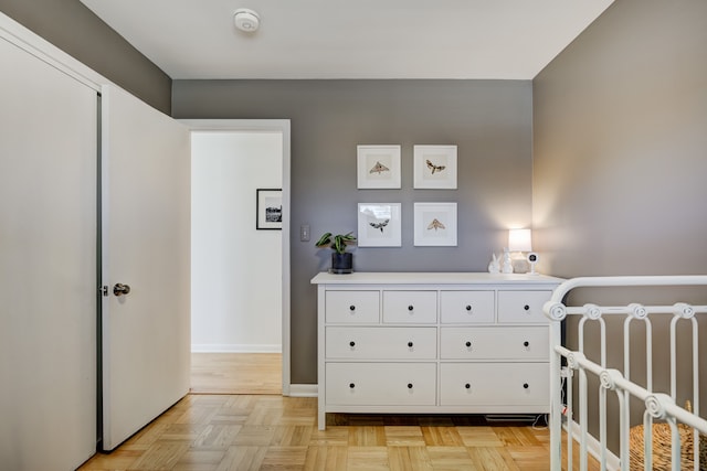 bedroom featuring a crib and baseboards