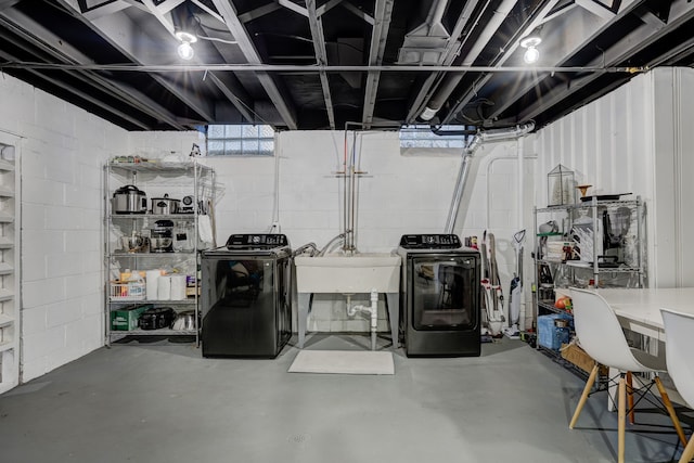 below grade area featuring a sink and washing machine and clothes dryer