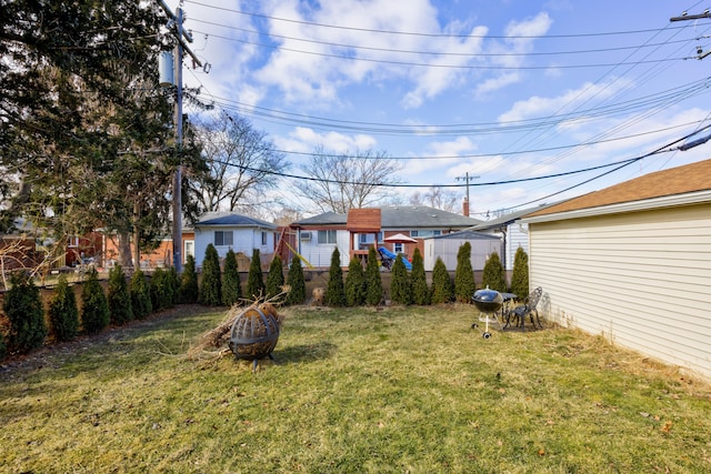 view of yard with an outdoor fire pit and fence