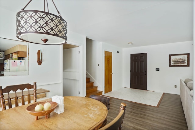 dining space featuring stairs and wood finished floors