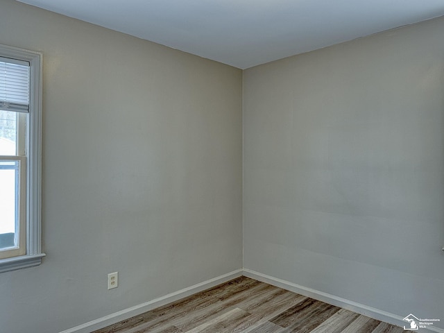 unfurnished room with baseboards and light wood finished floors