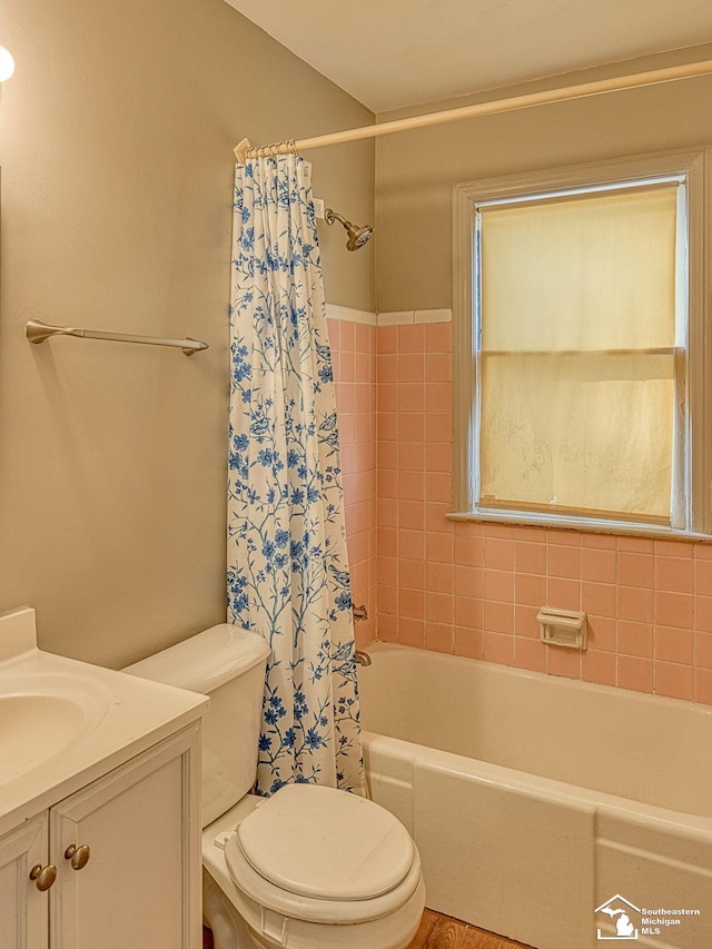 bathroom featuring toilet, shower / bath combo, and vanity