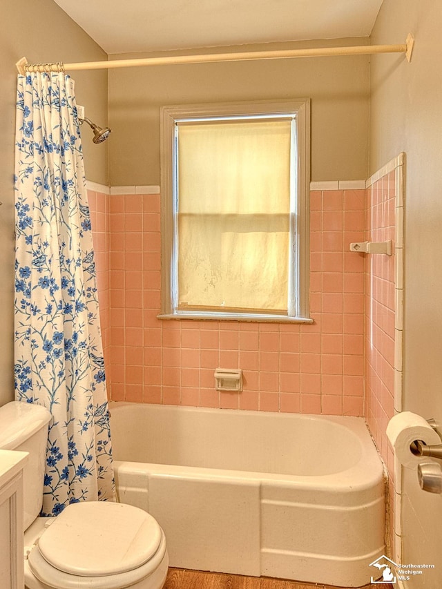 full bath featuring toilet, shower / bathtub combination with curtain, and vanity