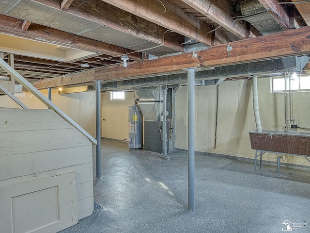 basement featuring heating unit, a sink, and gas water heater