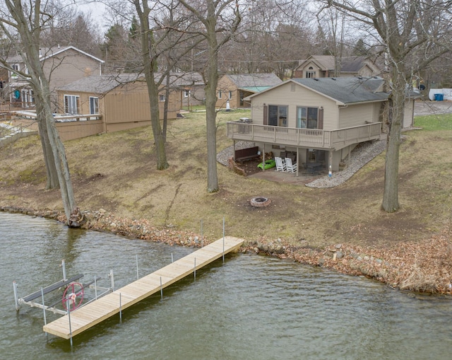 dock area with an outdoor fire pit and a deck with water view