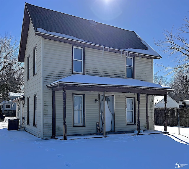 view of front of home with a porch, fence, and central AC unit