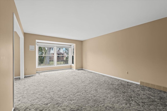 carpeted empty room with visible vents and baseboards