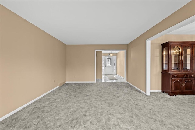 unfurnished room with baseboards and carpet flooring