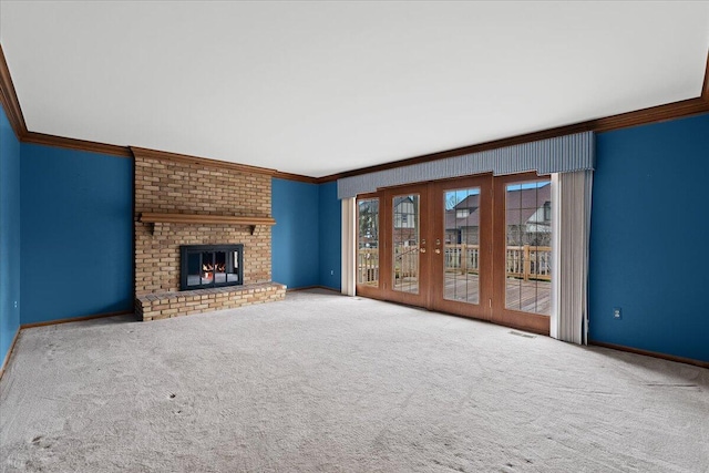 unfurnished living room with baseboards, ornamental molding, french doors, carpet floors, and a fireplace