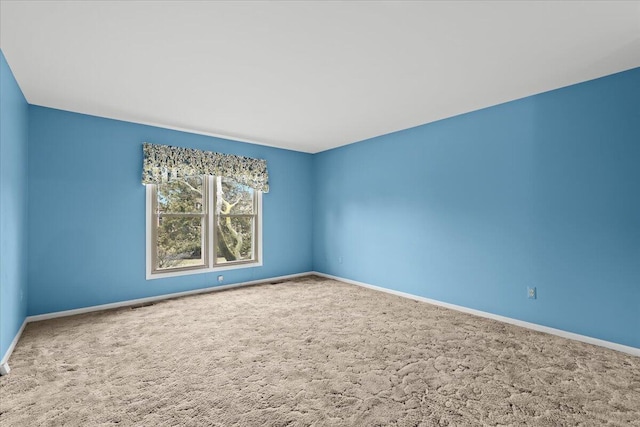 unfurnished room featuring carpet flooring, visible vents, and baseboards