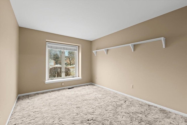 carpeted empty room with visible vents and baseboards