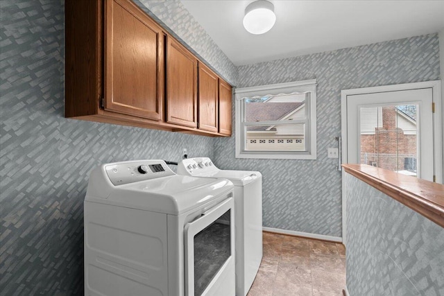 washroom with wallpapered walls, washing machine and dryer, baseboards, and cabinet space