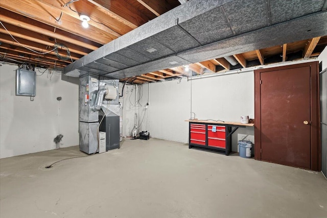 unfinished basement with electric panel and heating unit