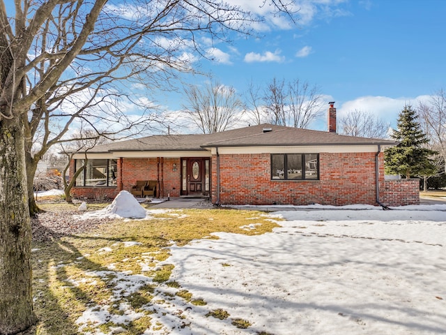 view of front of property with brick siding and a chimney