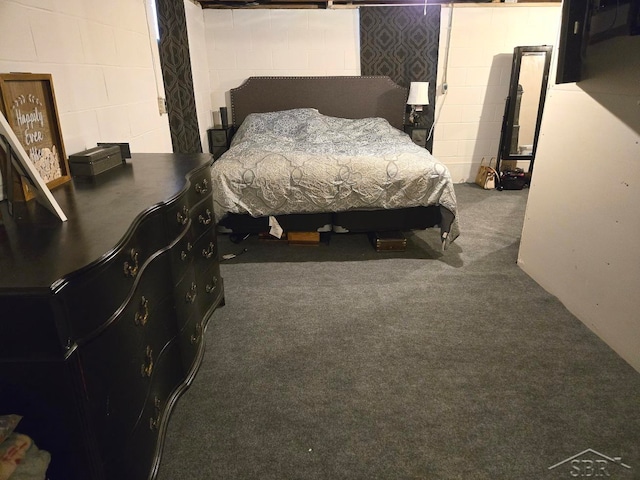 carpeted bedroom featuring concrete block wall